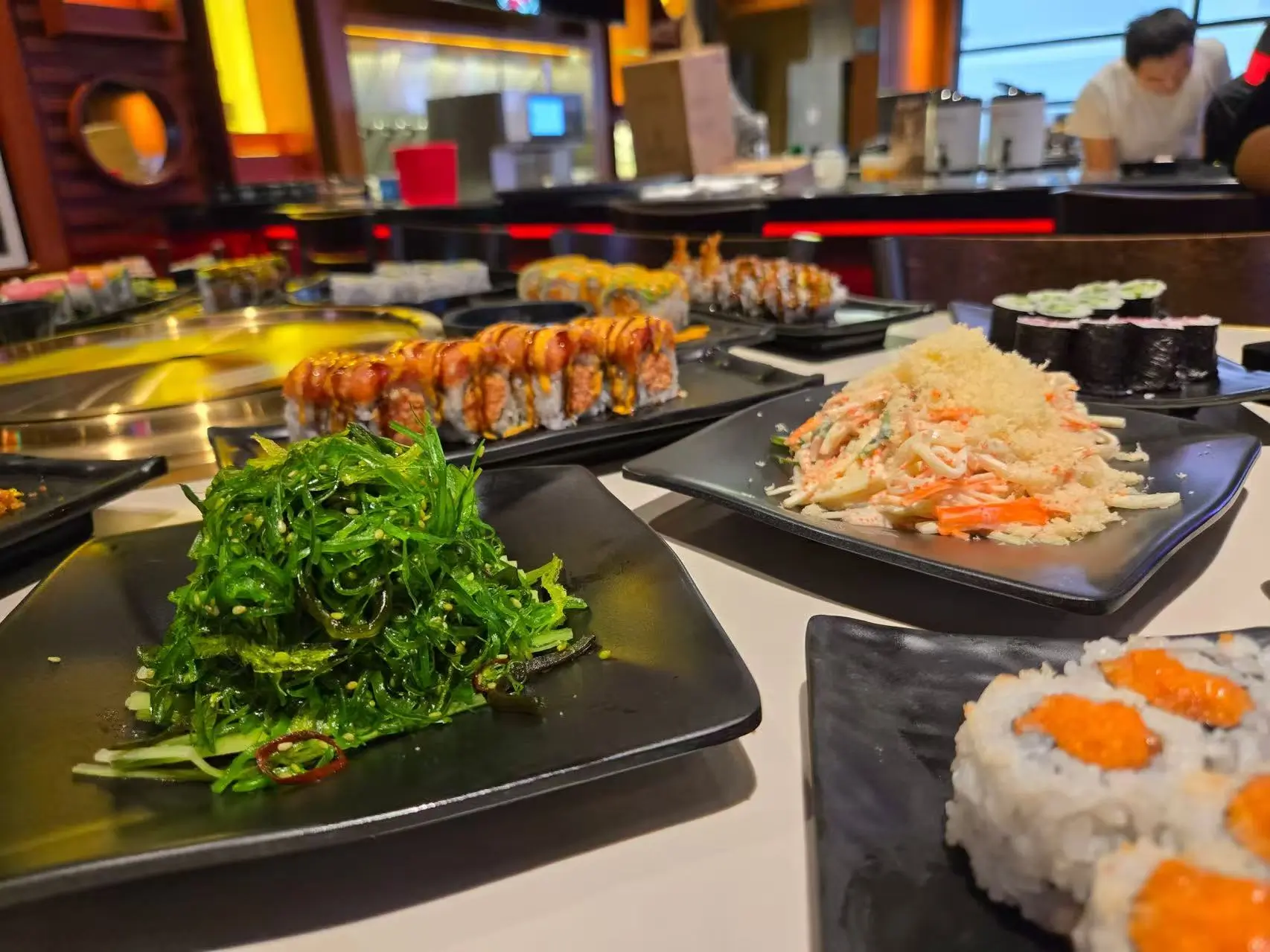 Assorted appetizers and sushi rolls including seaweed salad, crab salad, and spicy tuna roll at Daruma BBQ & Sushi AYCE, a Asian Restaurant in Holyoke