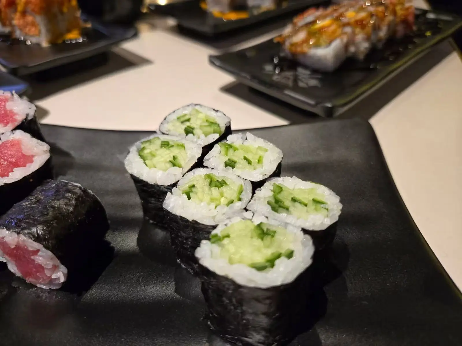 Cucumber maki and tuna maki rolls served on a black platter at Daruma BBQ & Sushi AYCE, a Asian Restaurant in Holyoke